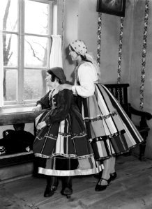 Twee jonge vrouwen in klederdracht kijken uit het raam in Lowicz, Bestanddeelnr 252-1287