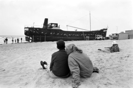 Twee toeschouwers zitten in het zand, Bestanddeelnr 934-4923