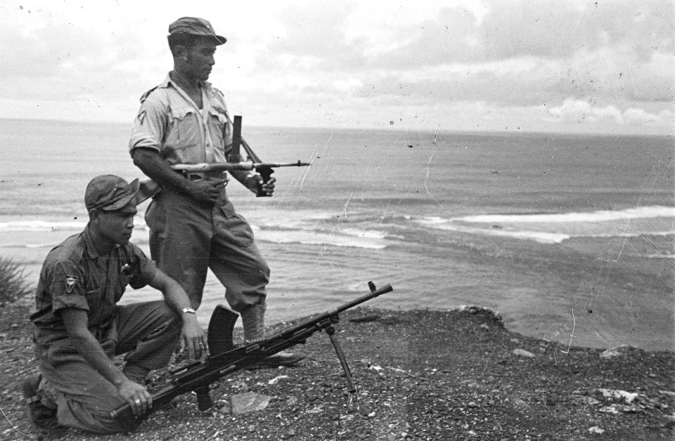 Twee militairen poseren met wapens bij de zee, Bestanddeelnr 163-4-4