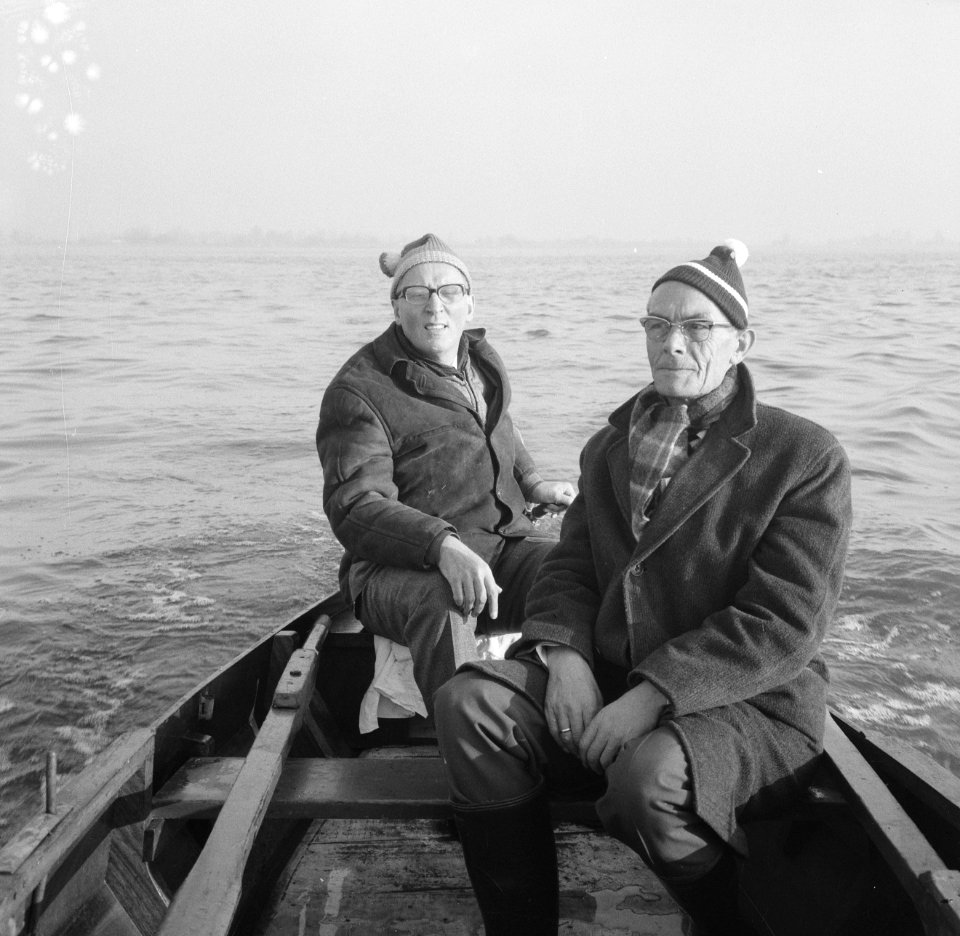 Twee sportvissers in een motorboot tijdens het varen, Bestanddeelnr 918-4480