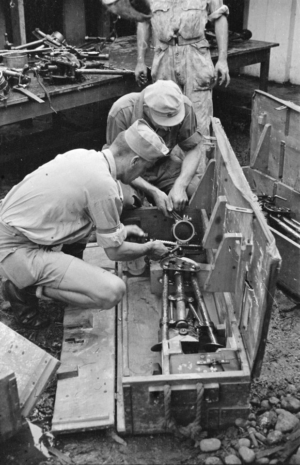 Twee militairen bezig met de montage van een mortier die in een wapenkist ligt, Bestanddeelnr 458-2-1