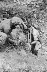 Twee militairen proberen een mortier omhoog te tillen, Bestanddeelnr 465-5-4