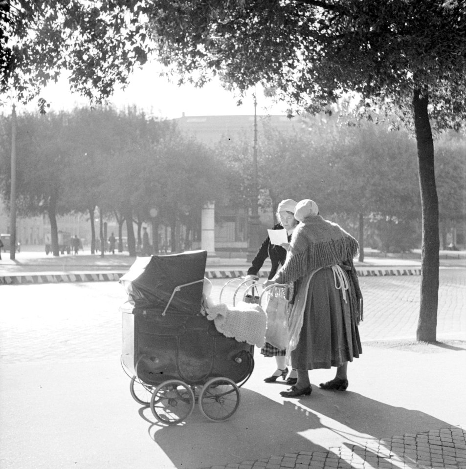 Twee vrouwen met kinderwagens maken op straat een praatje in de zon, Bestanddeelnr 254-5511