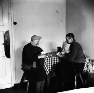 Twee vrouwelijke repatrianten zitten aan een tafel en eten, Bestanddeelnr 900-5091