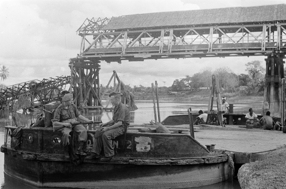 Twee soldten zitten op een ponton Achter hen de verwoeste houten brug, Bestanddeelnr 348-1-4