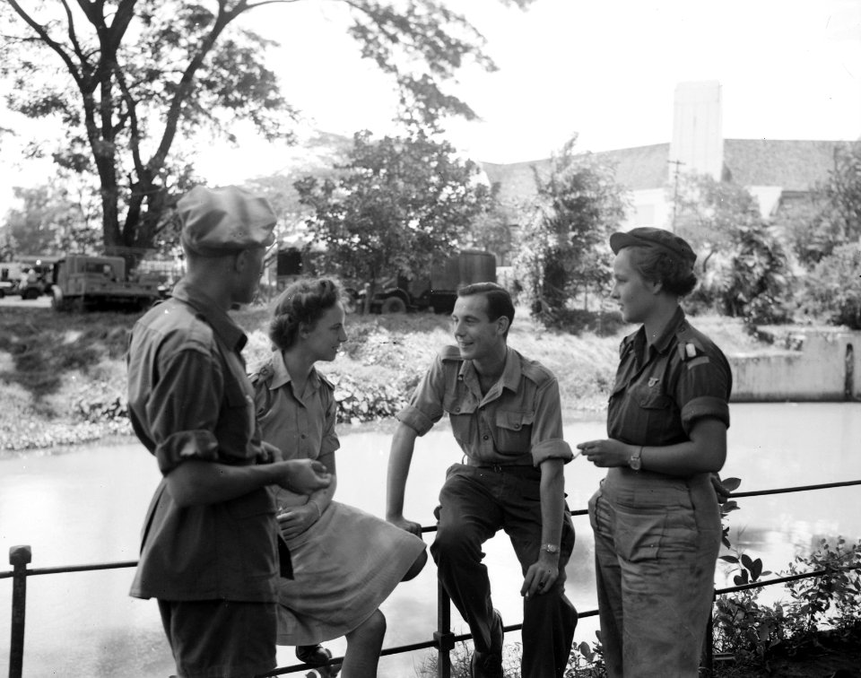 Twee mannen en twee vrouwen in uniform in gesprek aan een waterkant, Bestanddeelnr 8514