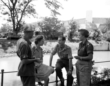 Twee mannen en twee vrouwen in uniform in gesprek aan een waterkant, Bestanddeelnr 8514