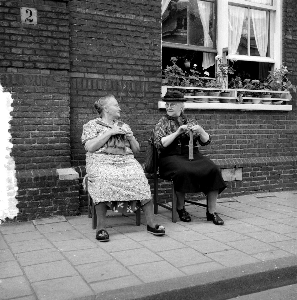 Twee oudere dames buiten voor een huis in de schaduw met breiwerk, Bestanddeelnr 907-2898