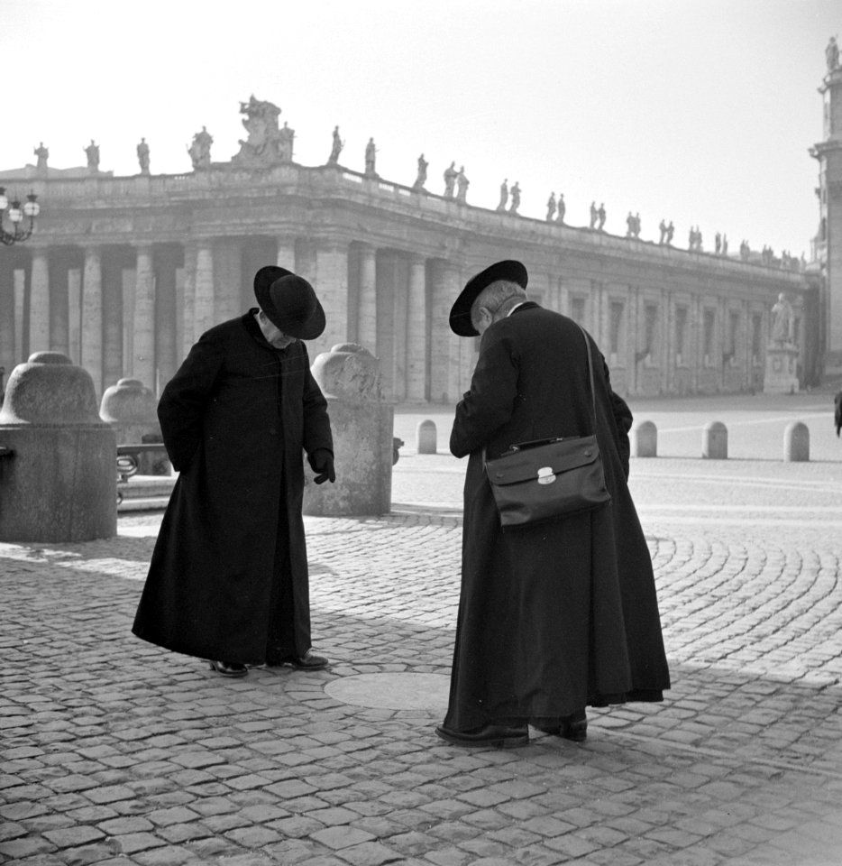 Twee priesters staan op het Sint-Pietersplein bij één van de stenen die het bran, Bestanddeelnr 191-1193