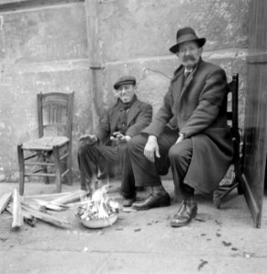 Twee mannen zitten bij vuur in een vuurpot op straat, Bestanddeelnr 254-5490