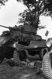 Tussen Humber pantserwagens is een dekzeil gehangen waaronder een militair in de, Bestanddeelnr 354-2-3