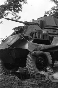 Tussen Humber pantserwagens is een dekzeil gehangen waaronder een militair in de, Bestanddeelnr 354-2-4