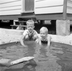 Twee blonde jongetjes bij een bak met water in Nickerie in Suriname, Bestanddeelnr 252-7021