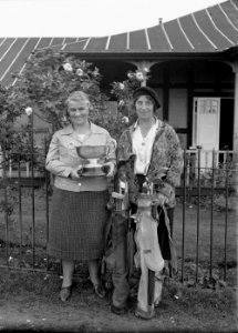 Two lady golfers outside Llandrindod Wells Golf Club pavilion, one holding the Open Challenge Bowl, 1933 (1294614)
