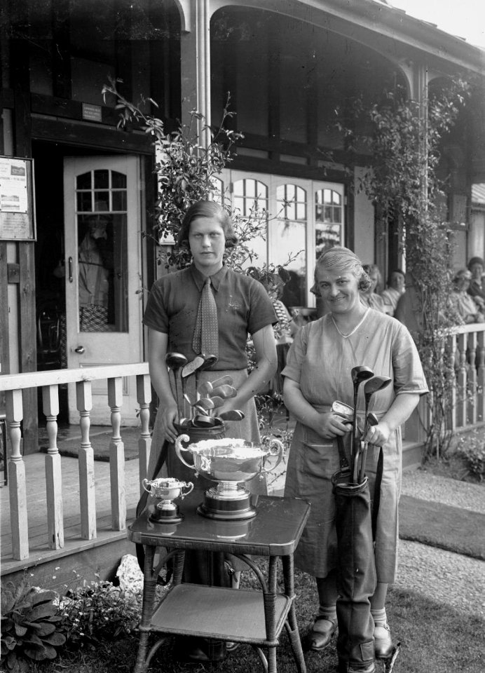 Two lady golfers beside a table with trophies outside Llandrindod Wells Golf Club pavilion (1294836)