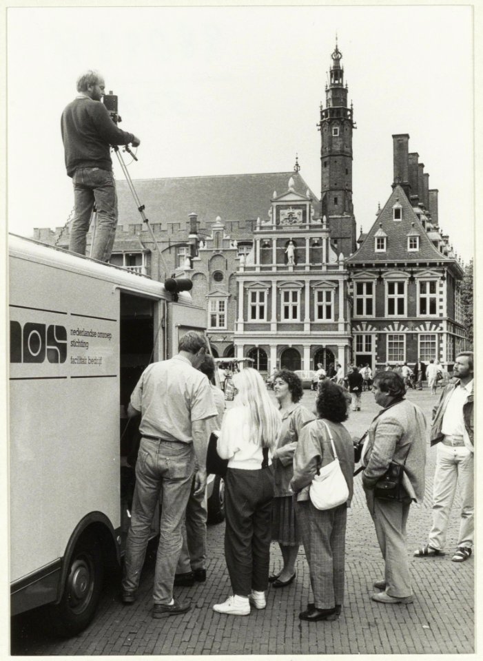 TV-opnamen voor de Teleac-cursus Steden en hun verleden op de Grote Markt, ziende naar het westen. NL-HlmNHA 54020803