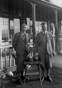 Two gentlemen golfers outside Llandrindod Wells Golf Club pavilion, with two cups (1294403)