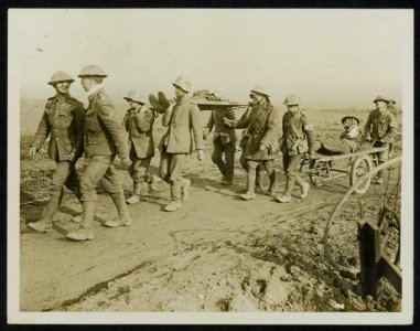Two German prisoners are seen in their steel hate bringing in an officer of the , Bestanddeelnr 158-0450