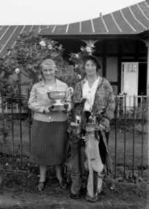 Two lady golfers outside Llandrindod Wells Golf Club pavilion, one holding the Open Challenge Bowl, 1933 (1295167)