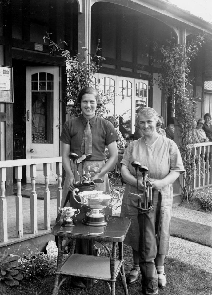 Two lady golfers beside a table with trophies outside Llandrindod Wells Golf Club pavilion (1293383)