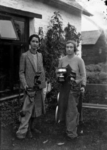 Two lady golfers with clubs, one holding a trophy (1294252)
