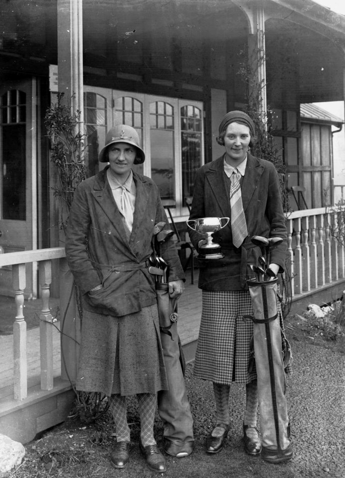 Two ladies in front of the Llandrindod Wells Golf Club pavilion, one with a trophy (1294624)
