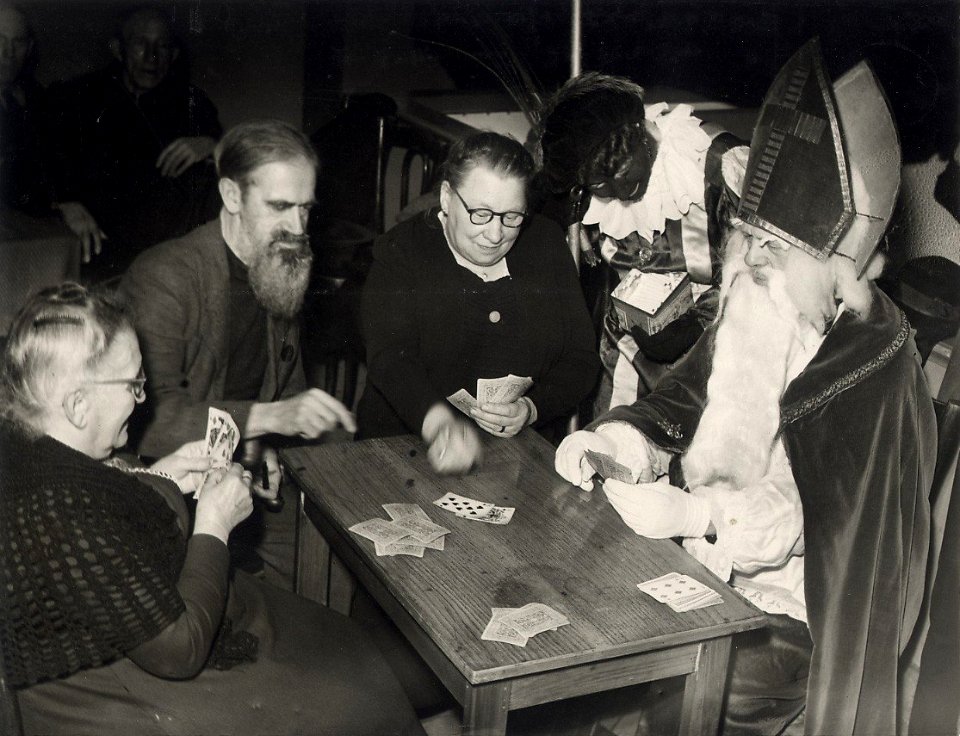 Onder toeziend oog van Zwarte Piet is het kaart spelen met Sint Nicolaas erg gezellig. Aangekocht in 1977 van fotograaf C. de Boer. Categorie 02-234.6 Identificatienummer 54-004266, NL-HlmNHA 54010752