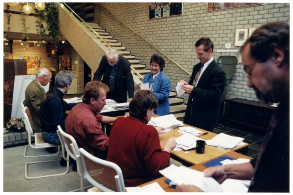 Onder leiding van burgemeester Dalhuisen tellen van de stemmen van de volksraadpleging over het fuseren van de gemeente Bennebroek met de gemeente Heemstede of de gemeente Bloemendaal. NL-HlmNHA 54037288