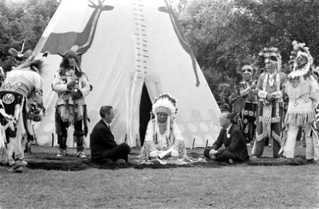 Prins Bernhard zit voor een wigwam en rookt de vredespijp, Bestanddeelnr 922-5496