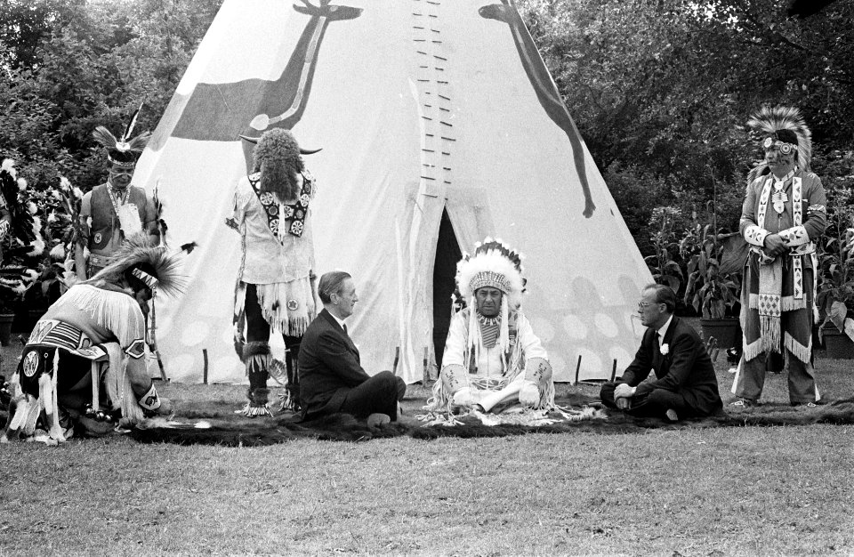 Prins Bernhard zit voor een wigwam en rookt de vredespijp, Bestanddeelnr 922-5497