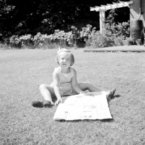 Prinses Margriet speelt met een krant op het grasveld bij het zomerhuisje, Bestanddeelnr 255-7867