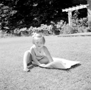 Prinses Margriet speelt met een krant op het grasveld bij het zomerhuisje, Bestanddeelnr 255-7865