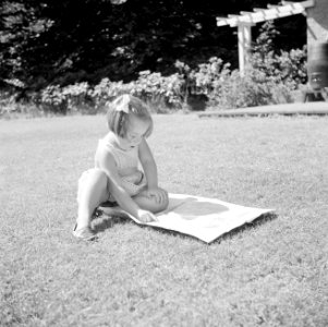 Prinses Margriet speelt met een krant op het grasveld bij het zomerhuisje, Bestanddeelnr 255-7866