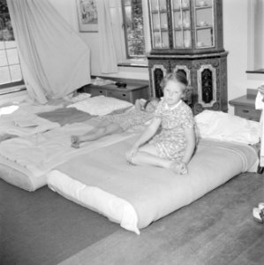 Prinses Beatrix zit op een bed en prinses Irene ligt op een bed in het zomerhuis, Bestanddeelnr 255-7889 photo