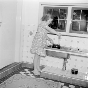 Prinses Beatrix vult een steelpan onder de kraan in de keuken van het zomerhuisj, Bestanddeelnr 255-7883