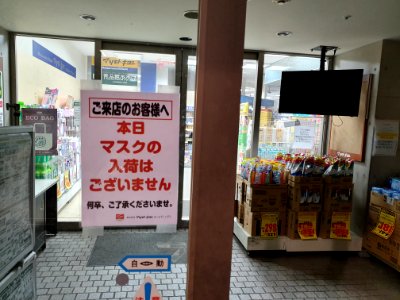 Poster saying "No masks" at Japanese supermarket entrance photo