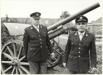 Portret van kapitein P. Schuler, kazernecommandant en een onbekende militair, poserend voor een kanon op het terrein van de Ripperda kazerne. NL-HlmNHA 54026212