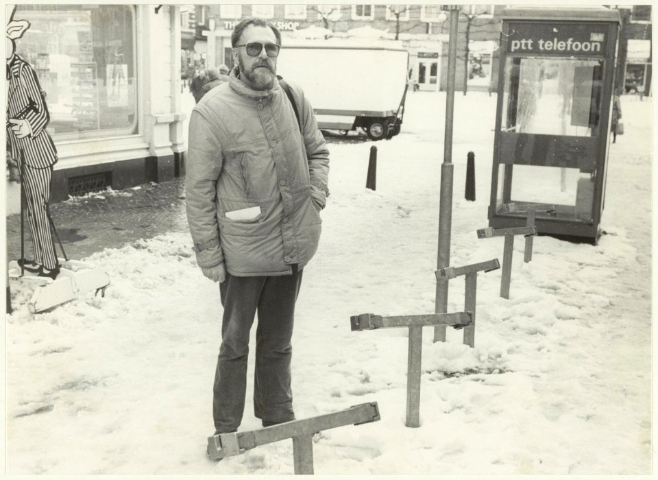 Portret van onbekend persoon bij de nieuw geplaatste fietsklemmen in de Grote Houtstraat, nabij de Grote Markt. NL-HlmNHA 54021141