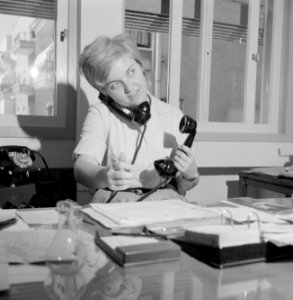 Portret van secretaresse Aviva terwijl ze telefoneert met twee telefoons, Bestanddeelnr 255-4525