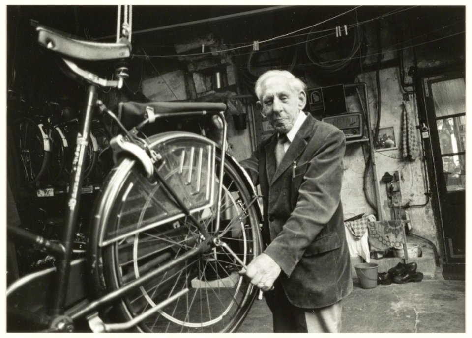 Portret van de heer J.A. Valk in zijn rijwielstalling en reparatie in de Cornelissteeg 15