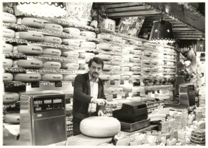 Portret van de heer Heeremans in de gelijknamige kaas- en wijnhandel aan de Rivièradreef, twee maanden na de brand in juli 1979. NL-HlmNHA 54010172