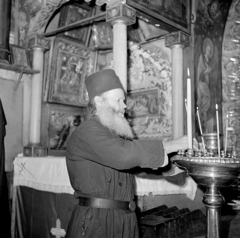 Priester plaatst kaarsen bij het altaar in de Heilige Grafkerk, Bestanddeelnr 255-5215
