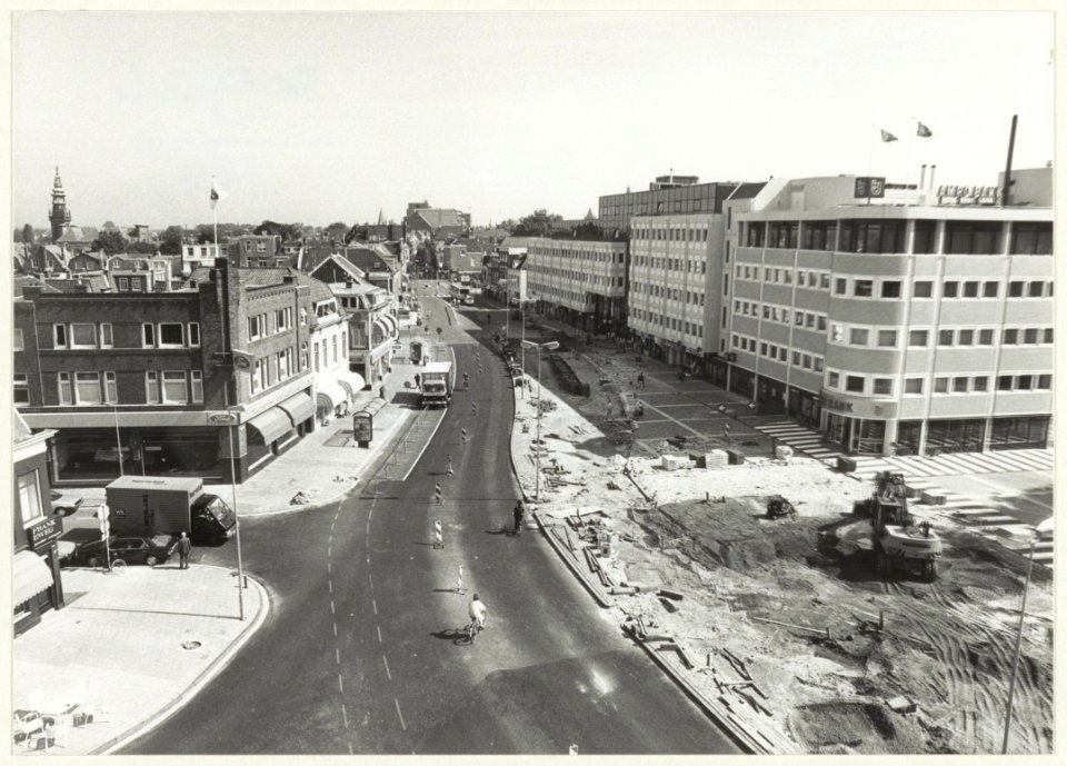 Reconstructie van het Houtplein i.v.m. de nieuwbouw rechts, ziende naar het noorden. Links op de achtergrond de toren van de Nieuwe Kerk en in het midden het gebouw van Vroom en Dreesmann aa, NL-HlmNHA 54023575