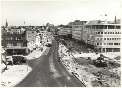 Reconstructie van het Houtplein i.v.m. de nieuwbouw rechts, ziende naar het noorden. Links op de achtergrond de toren van de Nieuwe Kerk en in het midden het gebouw van Vroom en Dreesmann aa, NL-HlmNHA 54023575