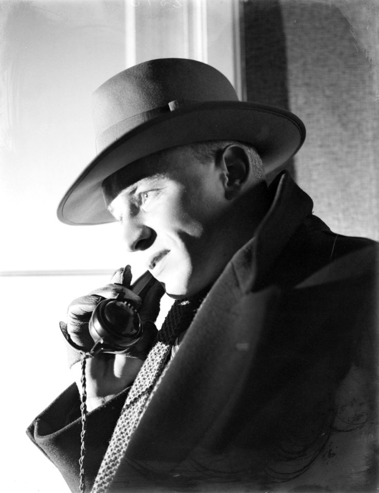 Reiziger met hoed met hoorn van telefoon in gehandschoende hand, Bestanddeelnr 252-1002