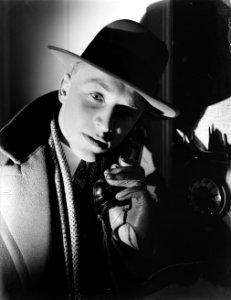 Reiziger met hoed met hoorn van telefoon in gehandschoende hand, rechts telefoon, Bestanddeelnr 252-1001 photo
