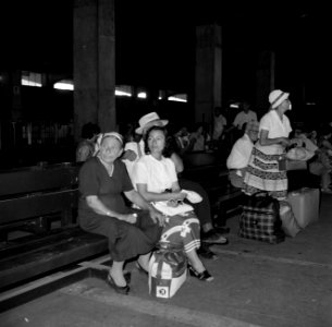 Reizigers met bagage wachten in een hal op houten zitbanken, Bestanddeelnr 255-2208