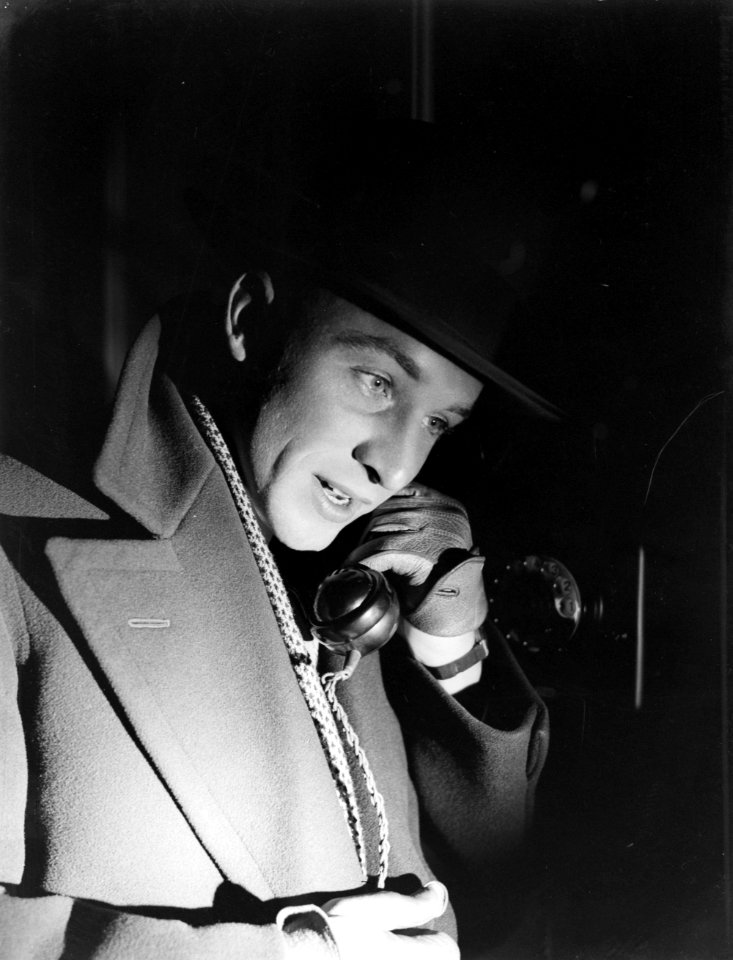 Reiziger met hoed met hoorn van telefoon in gehandschoende hand, Bestanddeelnr 252-1003