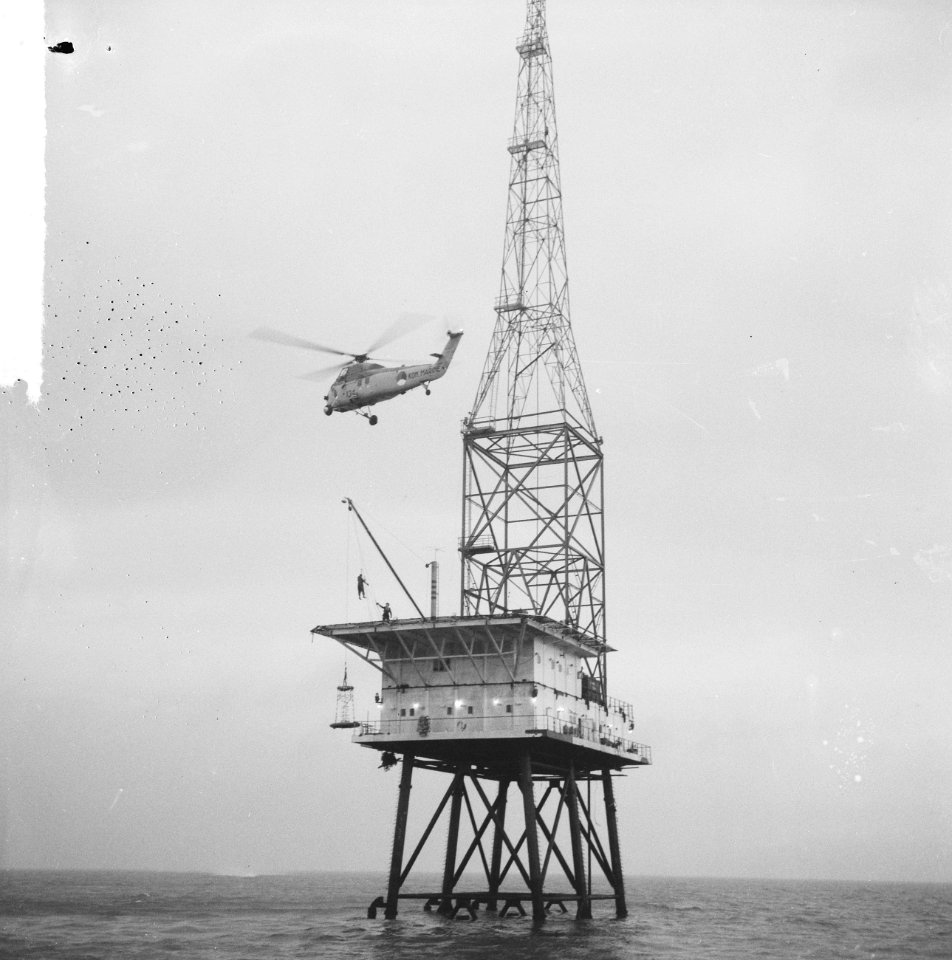 REM-eiland bezet, een helicopter laat een agent zakken op het landingsplatform, Bestanddeelnr 917-2550