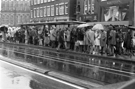 Regen in Amsterdam wachten bij tramhalte, Bestanddeelnr 927-3045